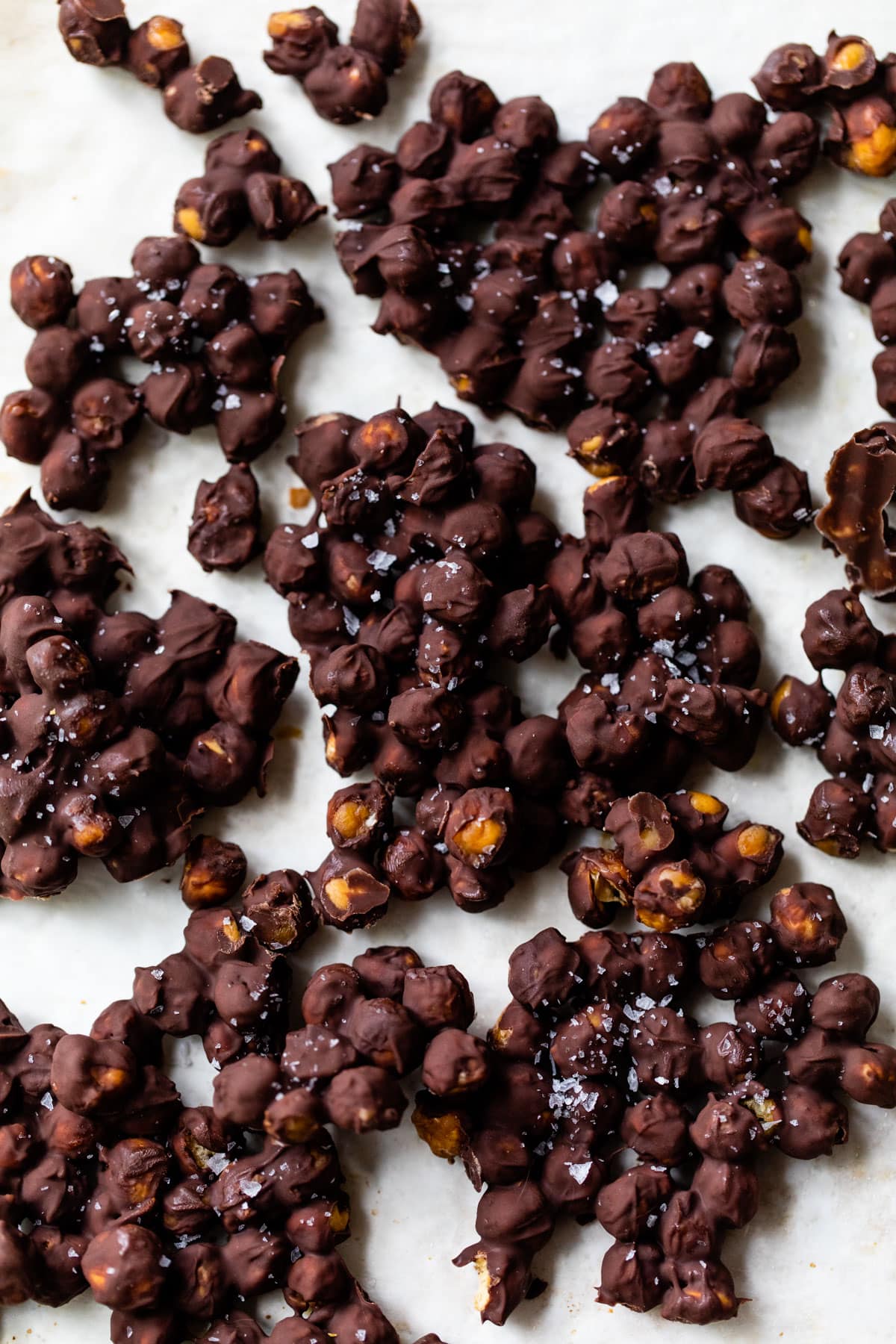 clumps of chocolate covered chickpeas on parchment paper