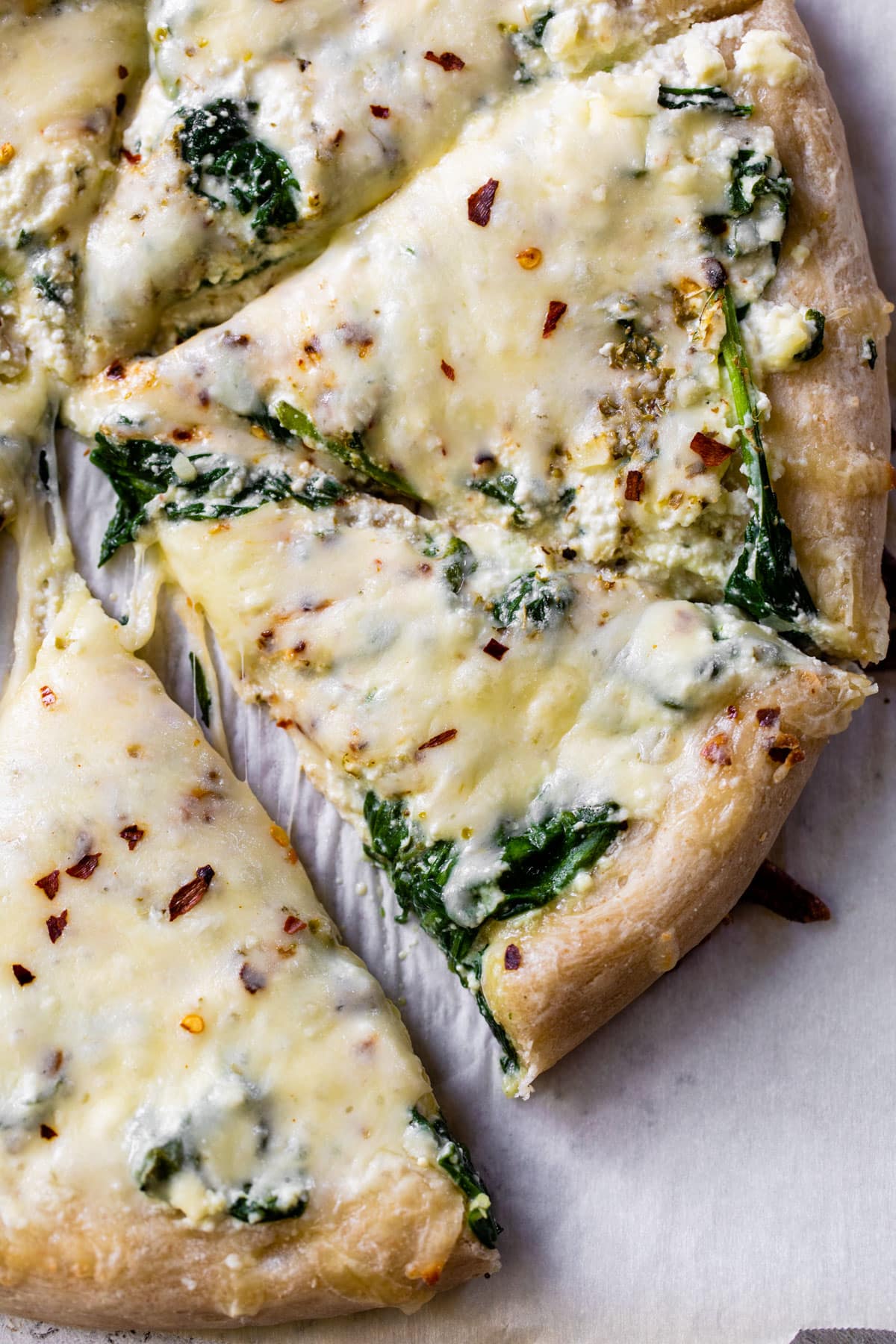 sliced cheese and spinach pizza