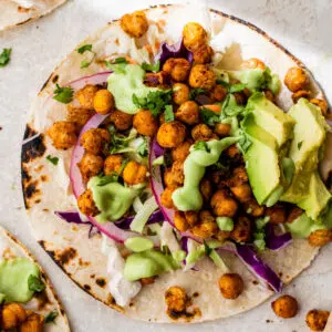 taco shell topped with chickpeas, red onion and avocado