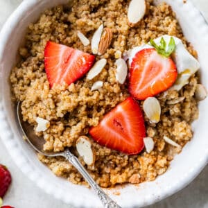 a bowl of quinoa topped with sliced strawberries and almonds