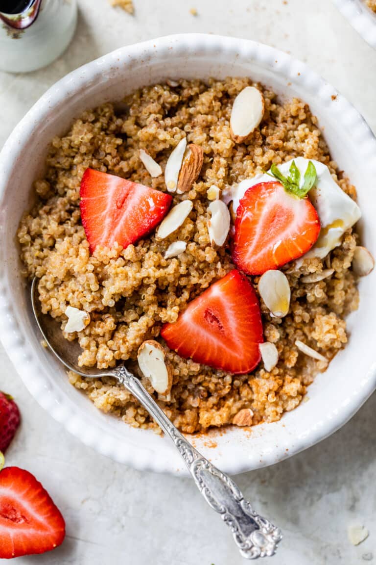 a bowl of quinoa topped with sliced strawberries and almonds