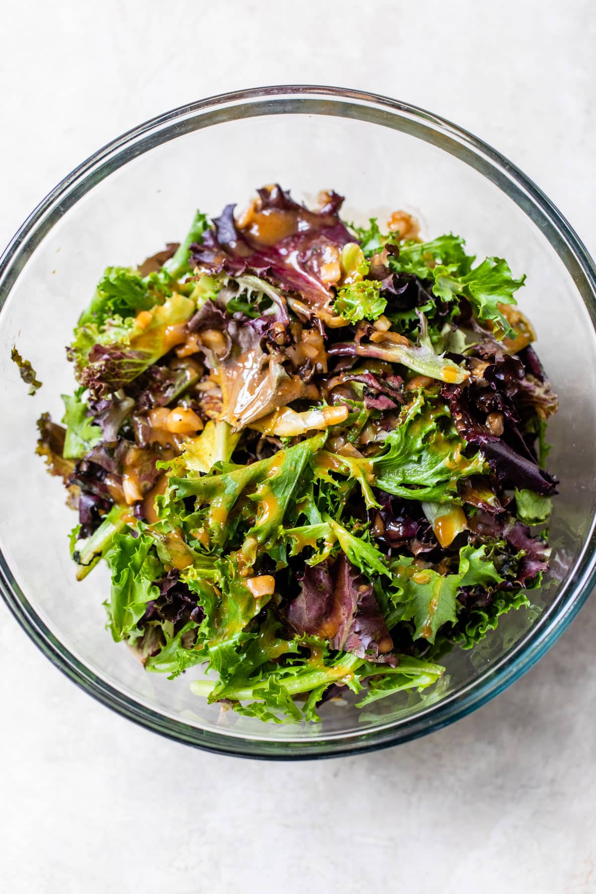 mixed greens in a bowl topped with balsamic viniagrette
