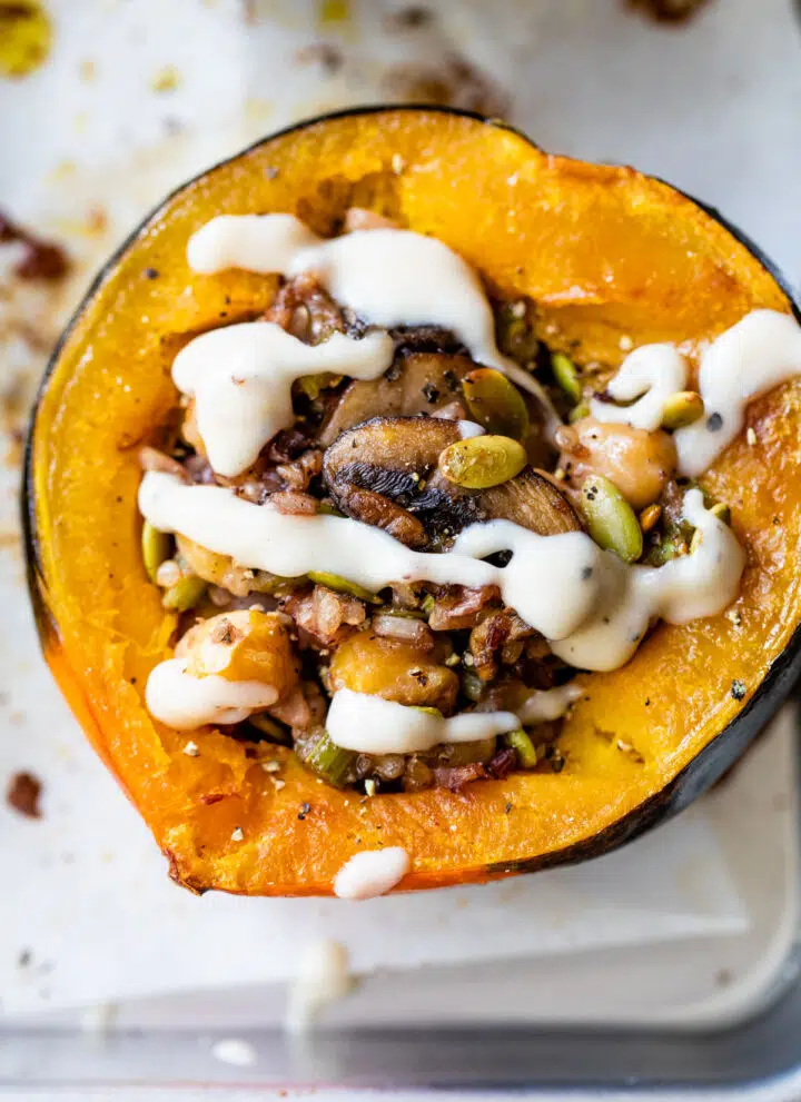 baked acorn squash stuffed with rice and drizzled with a white sauce