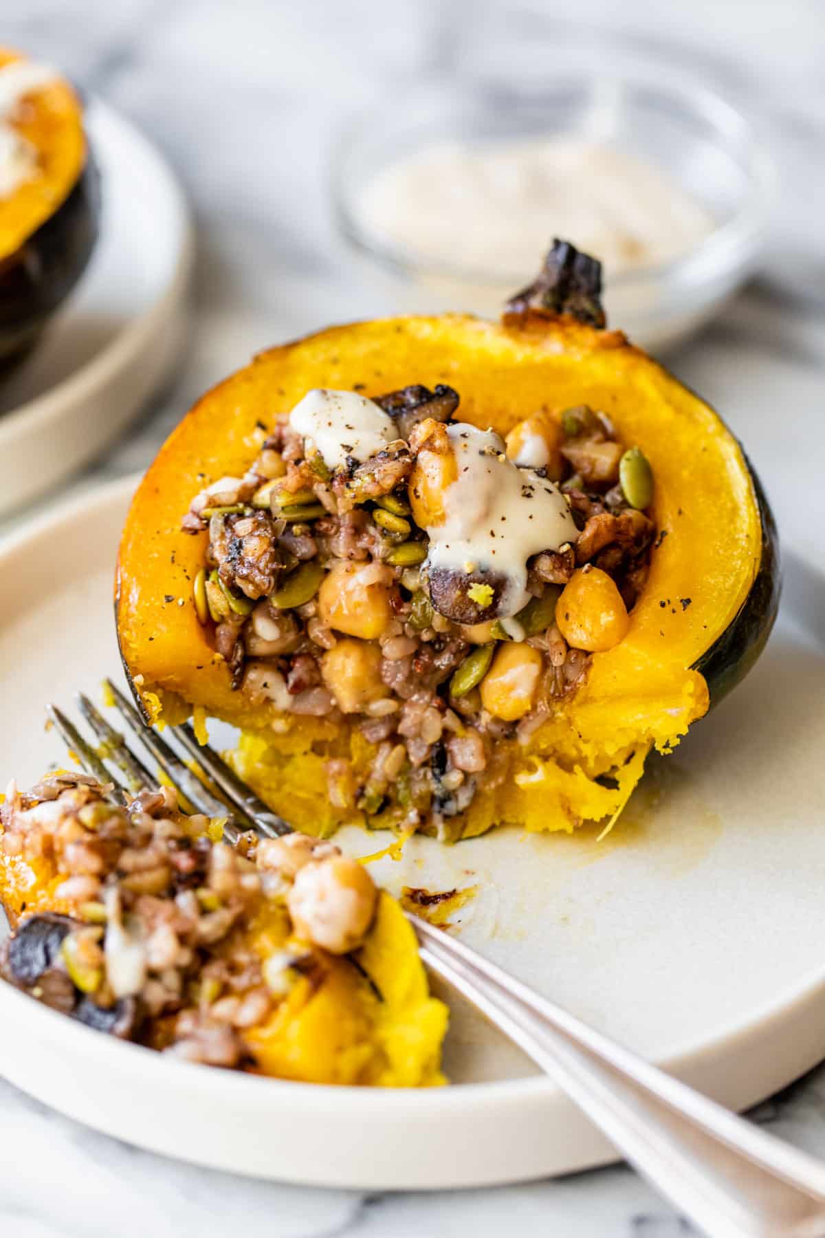 acorn squash filled with rice and chickpeas on a plate with a fork