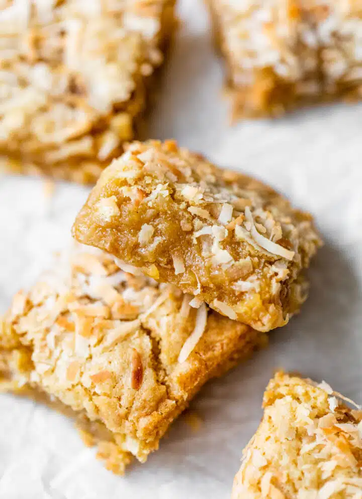 buttery bars with coconut on parchment paper