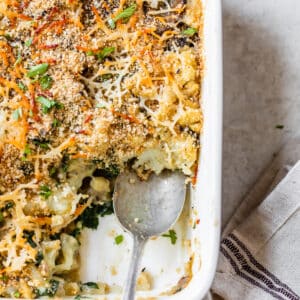 cauliflower in a casserole dish with breadcrumbs and a spoon