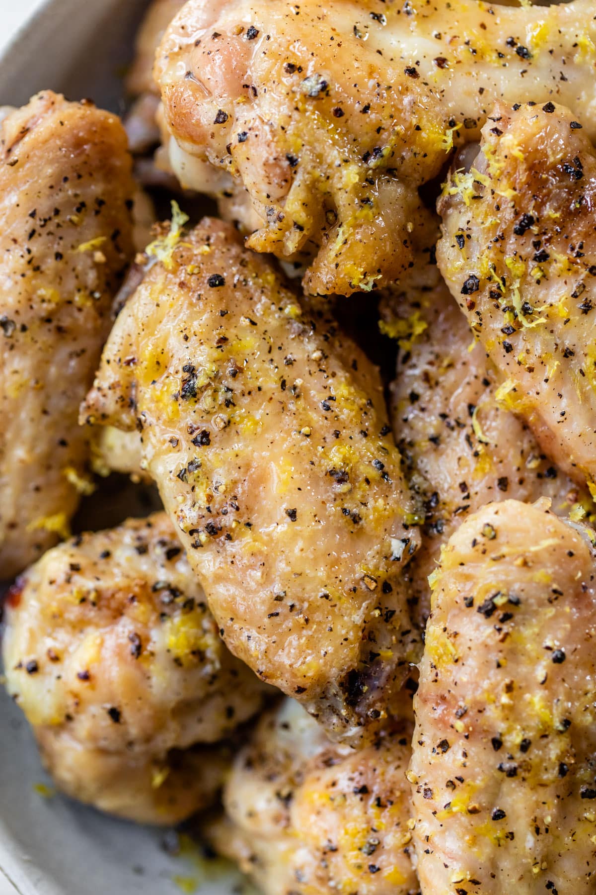 close up of chicken wings with lemon zest and black pepper