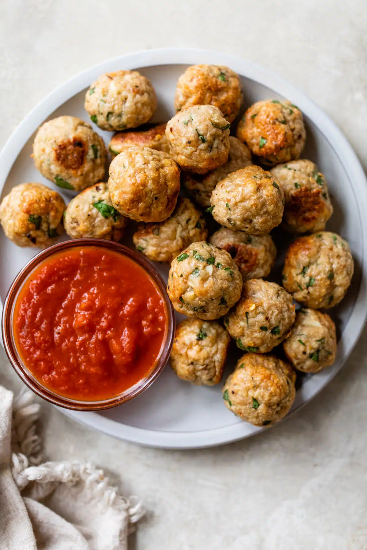 a plate filled with meatballs and a small bowl of marinara sauce