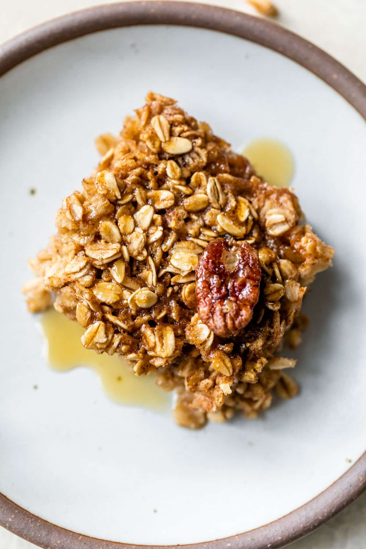 a piece of oatmeal topped with a pecan and maple syrup