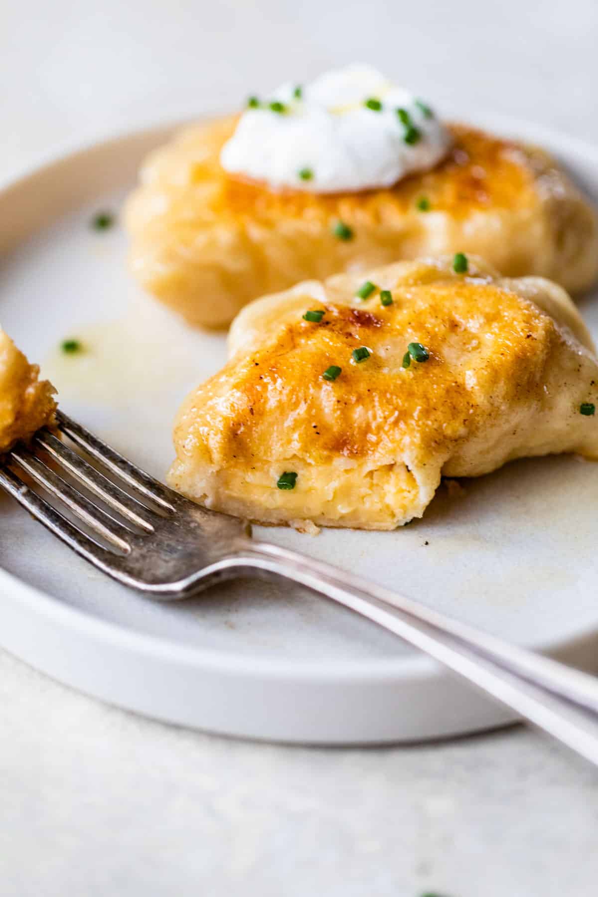 pierogi on a plate being cut with a fork