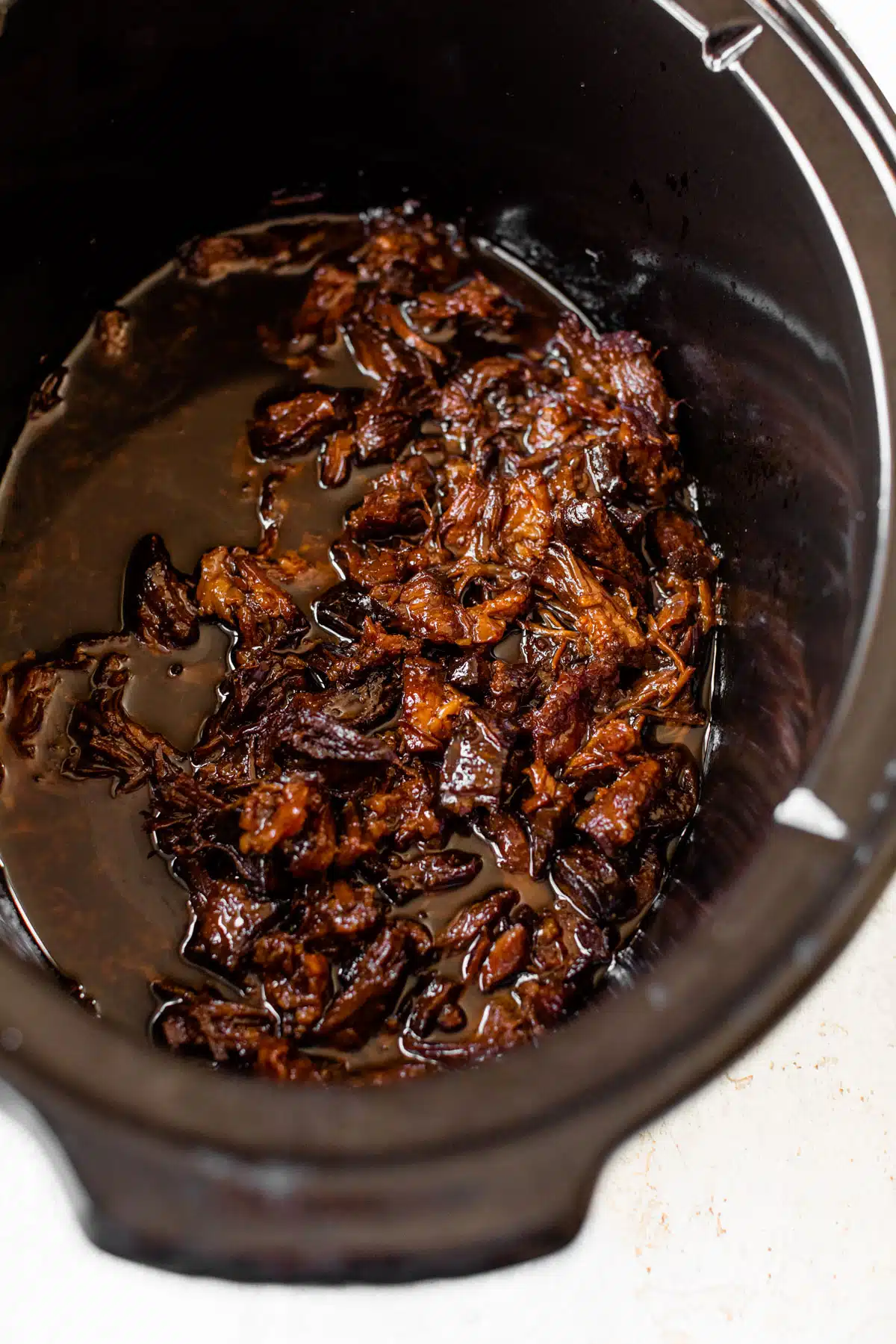 slow cooker filled with marinated pulled pork