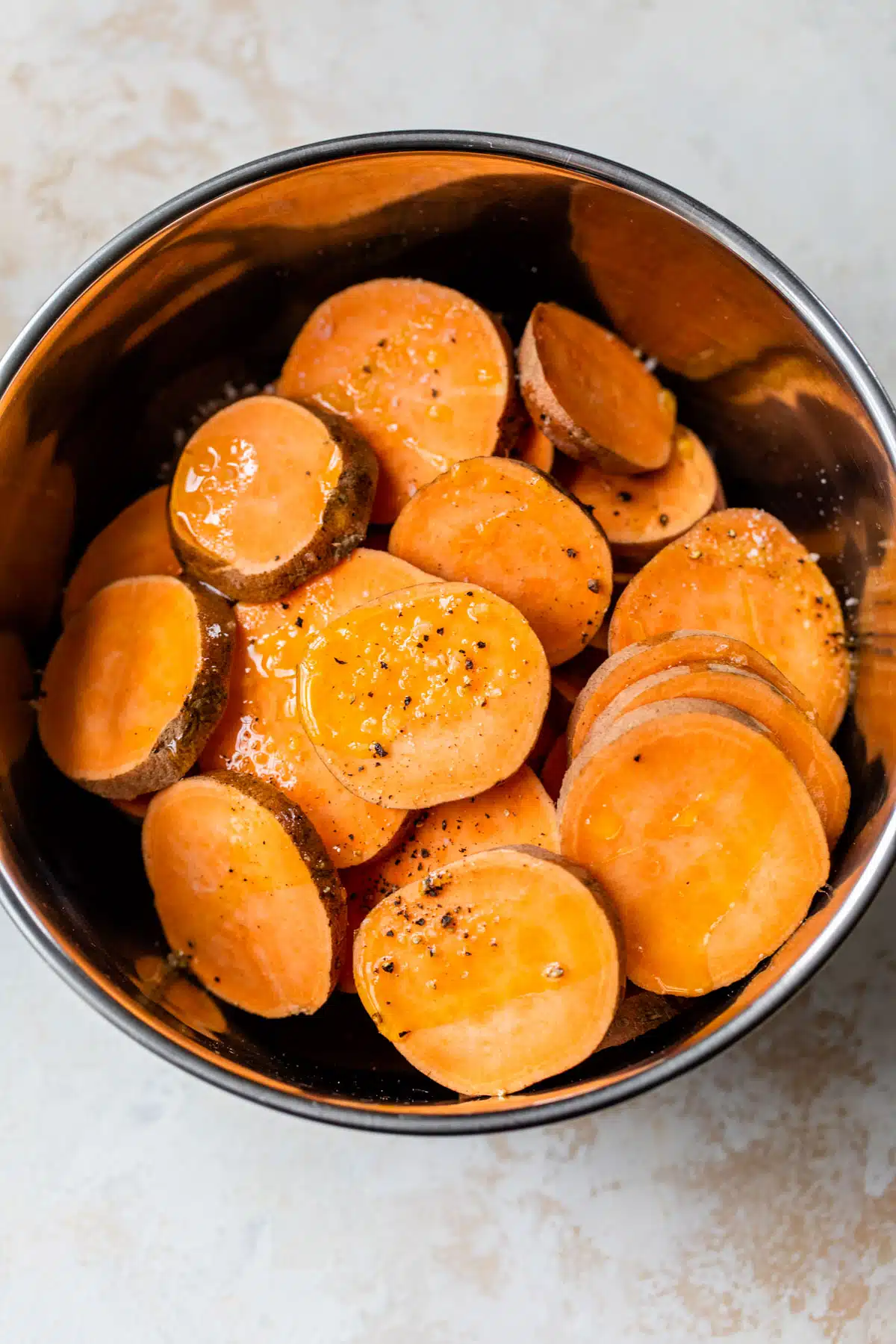 raw seasoned baked sweet potato slices in a bowl
