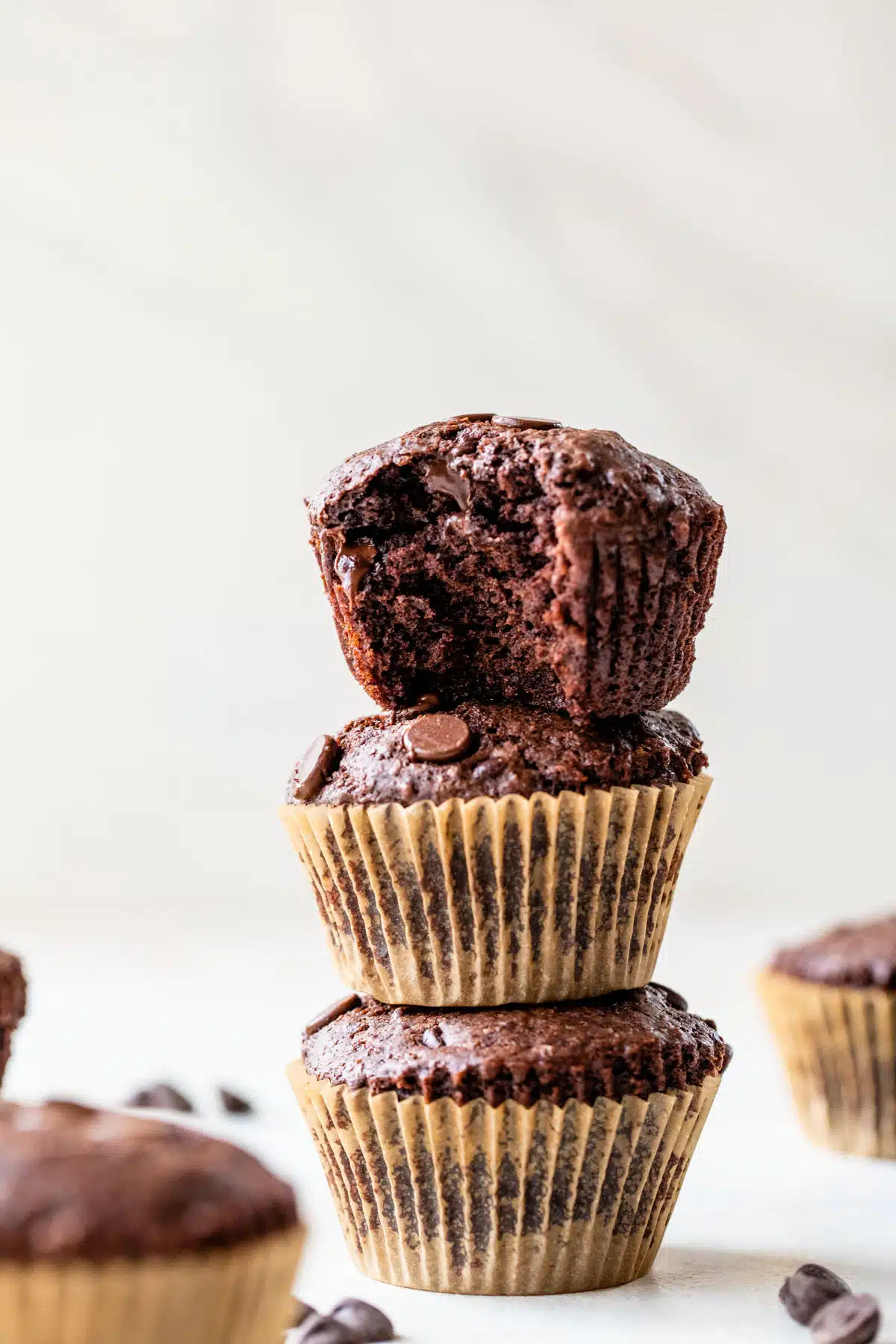 three vegan chocolate muffins stacked on top of each other