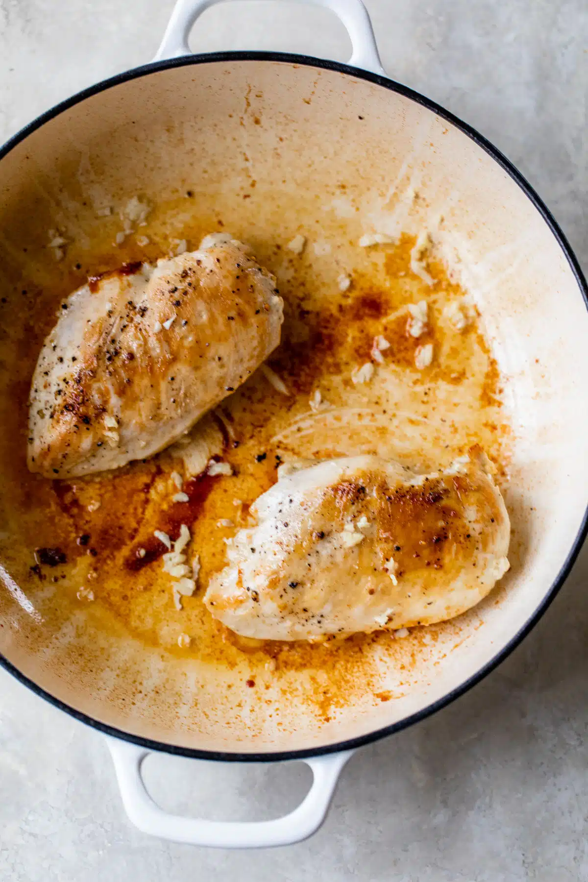 a dutch oven with 2 baked chicken breasts inside