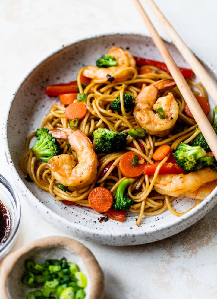 shrimp lo mein in a bowl with chopsticks
