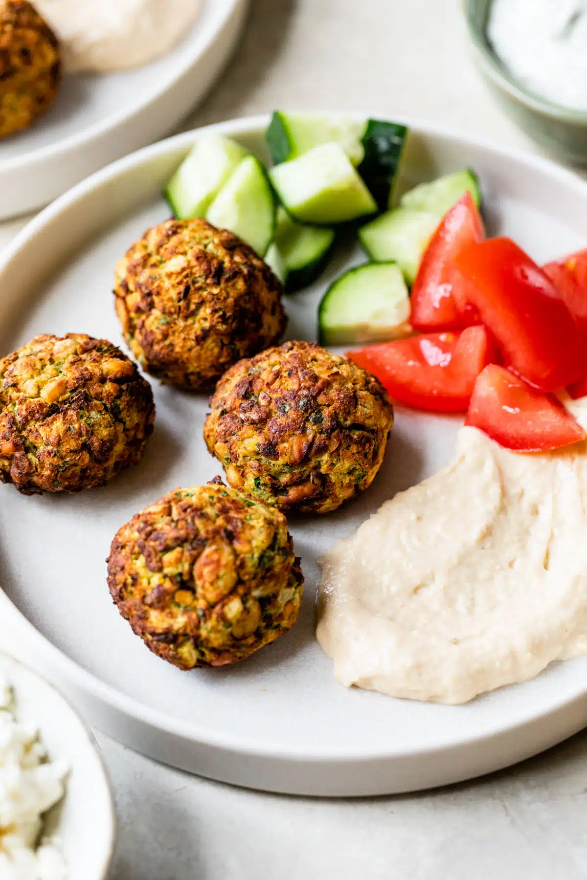 falafel on a plate with hummus, tomatoes and cucumber