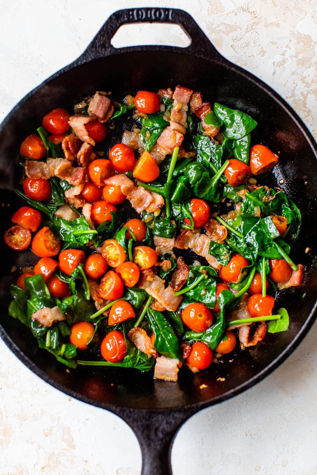 bacon and vegetables in a cast iron skillet