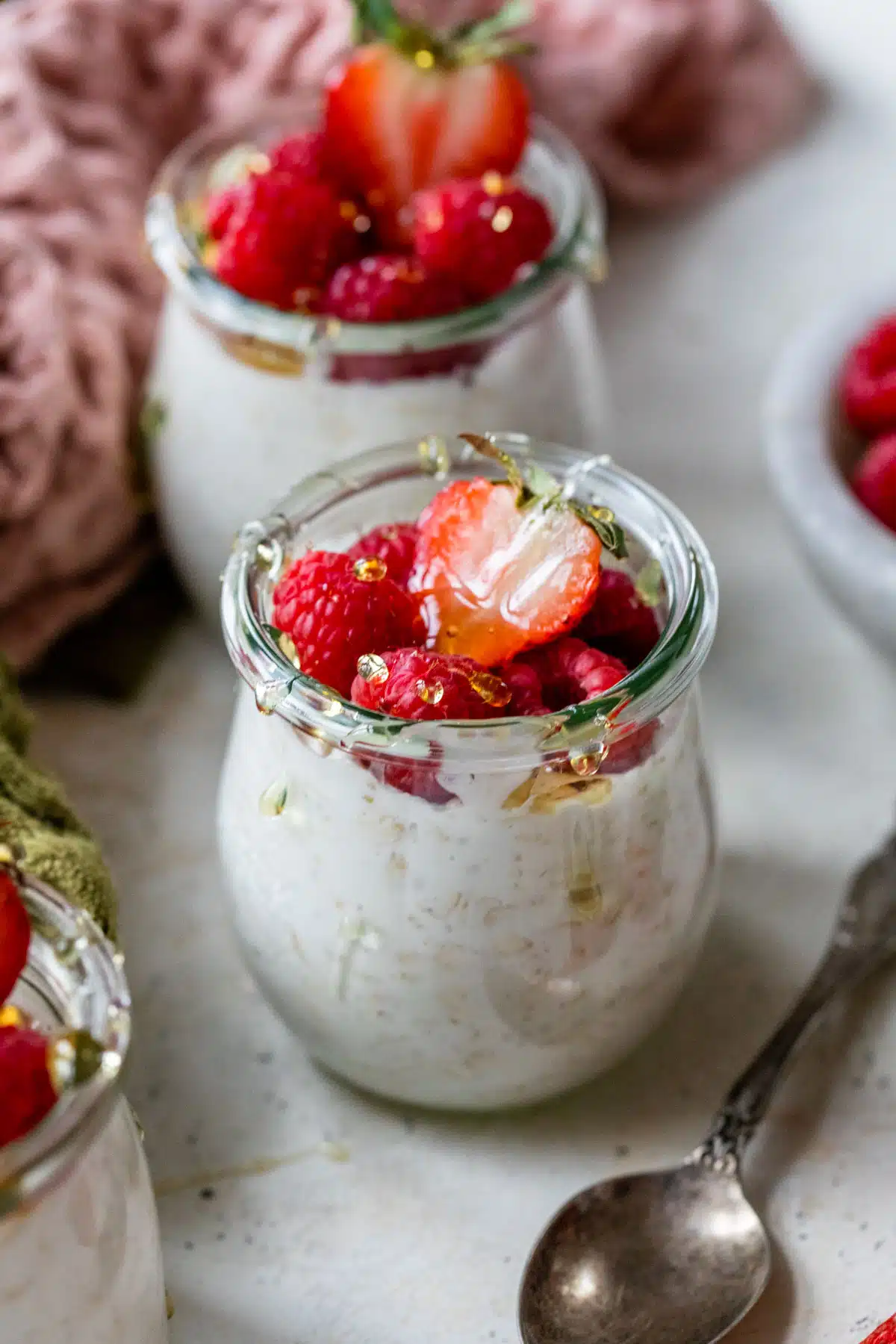 overnight oats in a mason jar with raspberries and strawberries on top