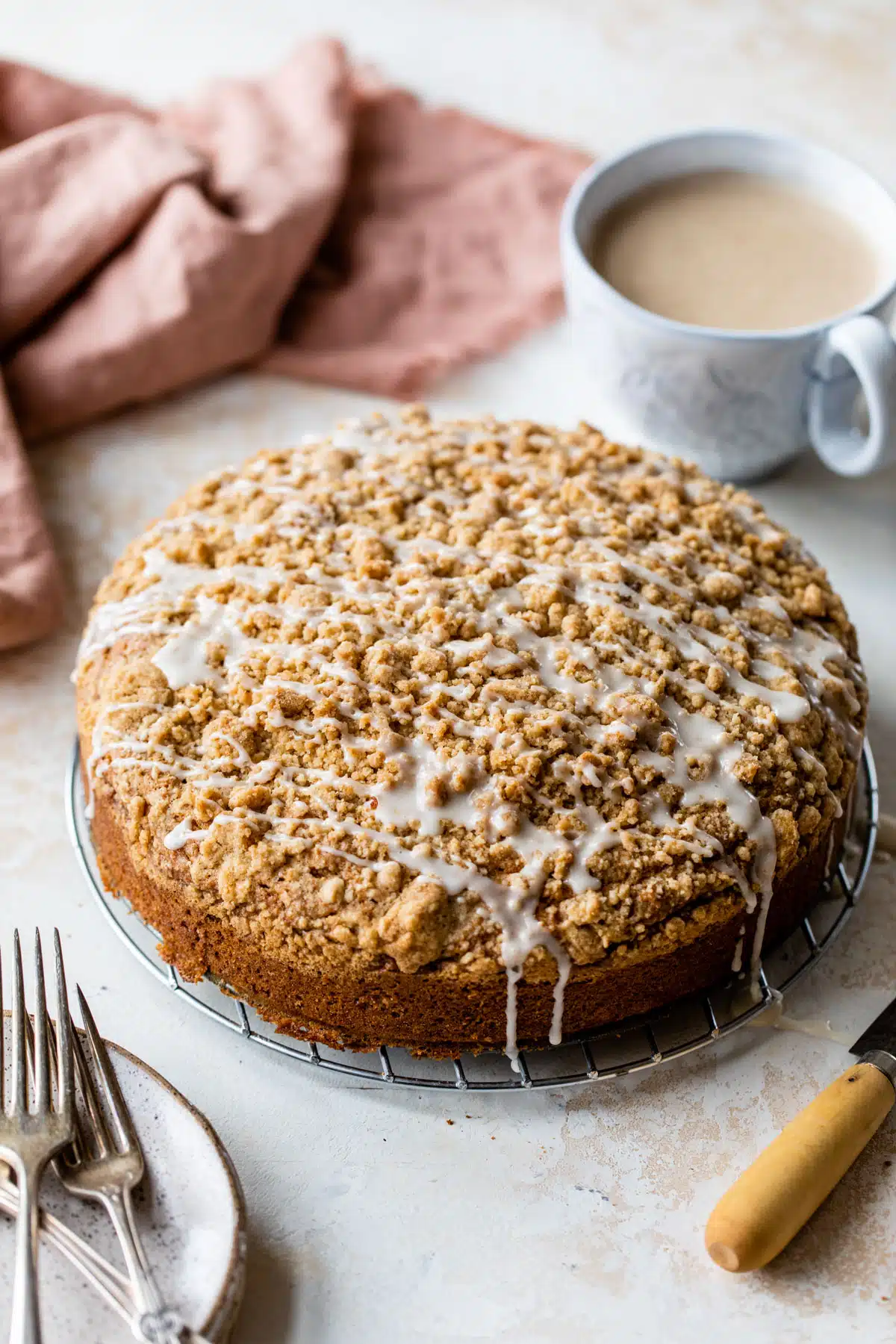 an overview of a whole vegan coffee cake with vanilla icing drizzled on top