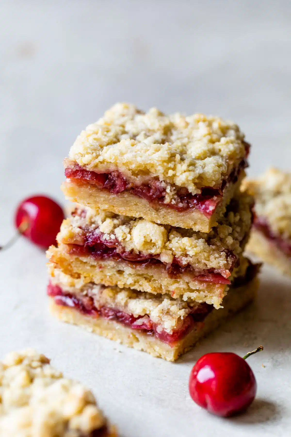 a stack of 3 dessert bars filled with cherries