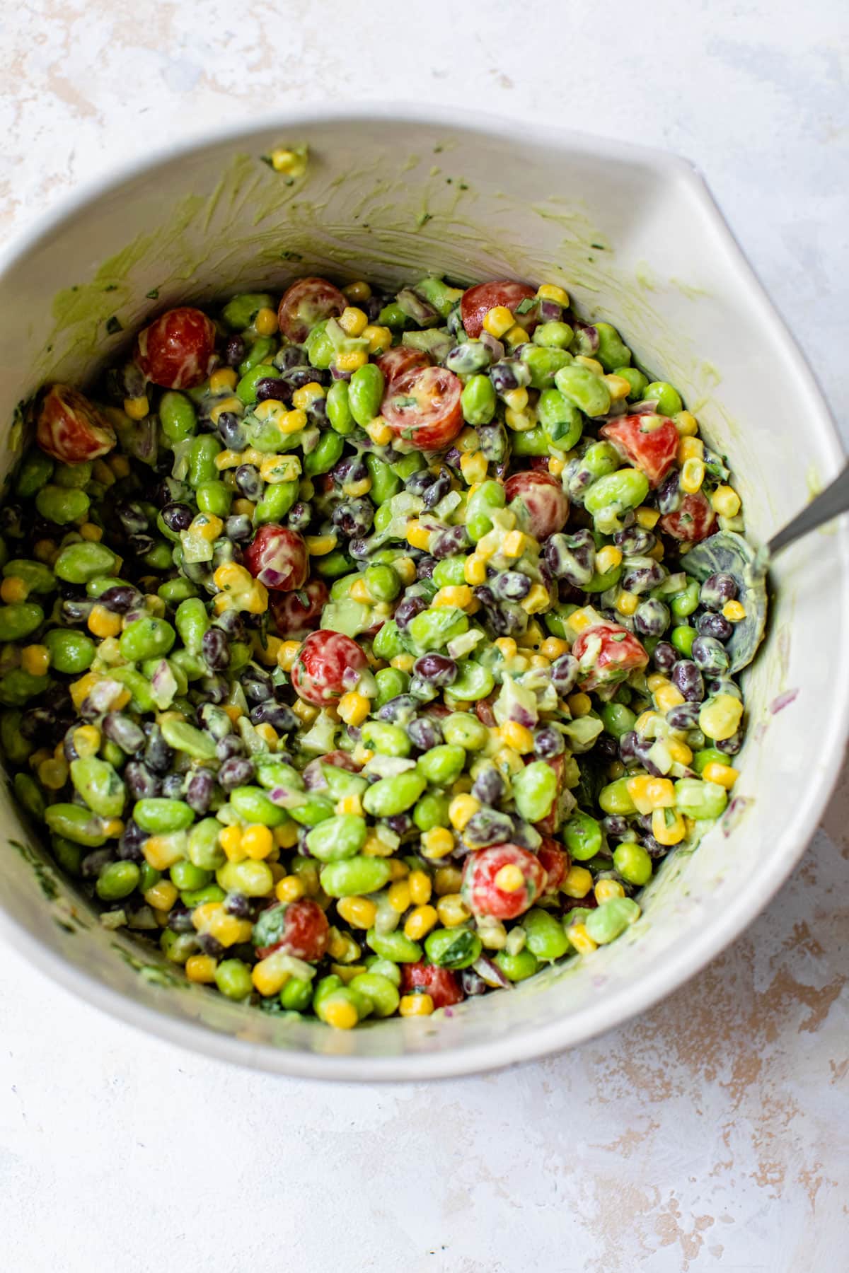 edamame salad just mixed together in a large bowl with a spoon