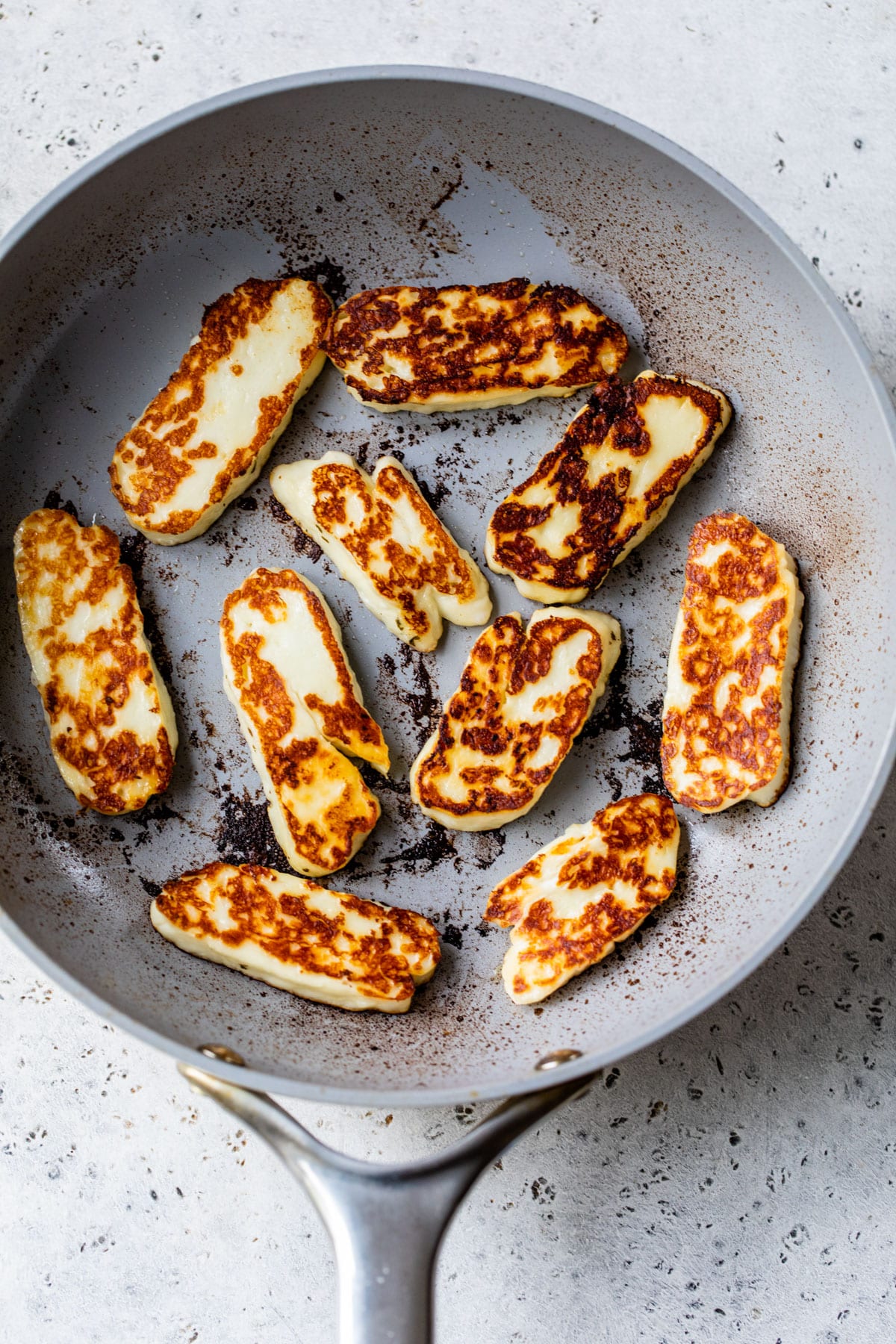fried halloumi slices in a skillet