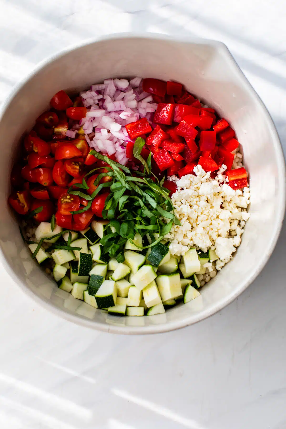 all ingredients for the vegetable couscous separated in a mixing bowl