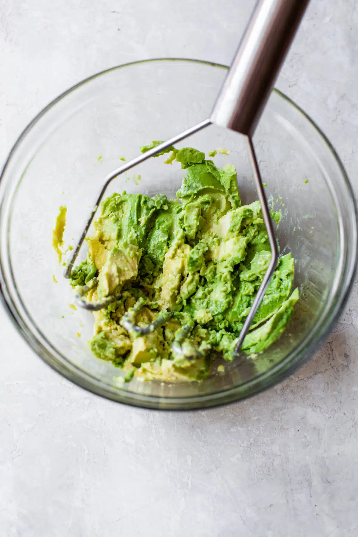 mashed avocado in a glass bowl