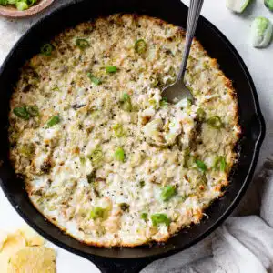 brussels sprouts dip cooked in a cast iron skillet with a spoon