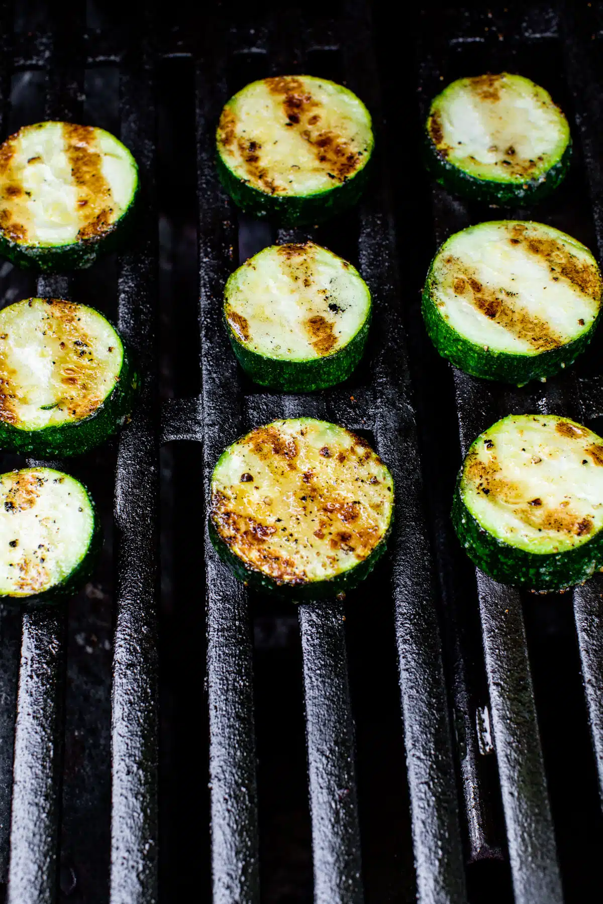 zucchini slices cooking on a grill