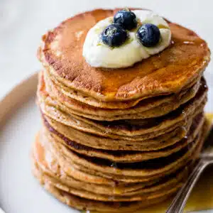 a stack of pancakes with yogurt and blueberries on top