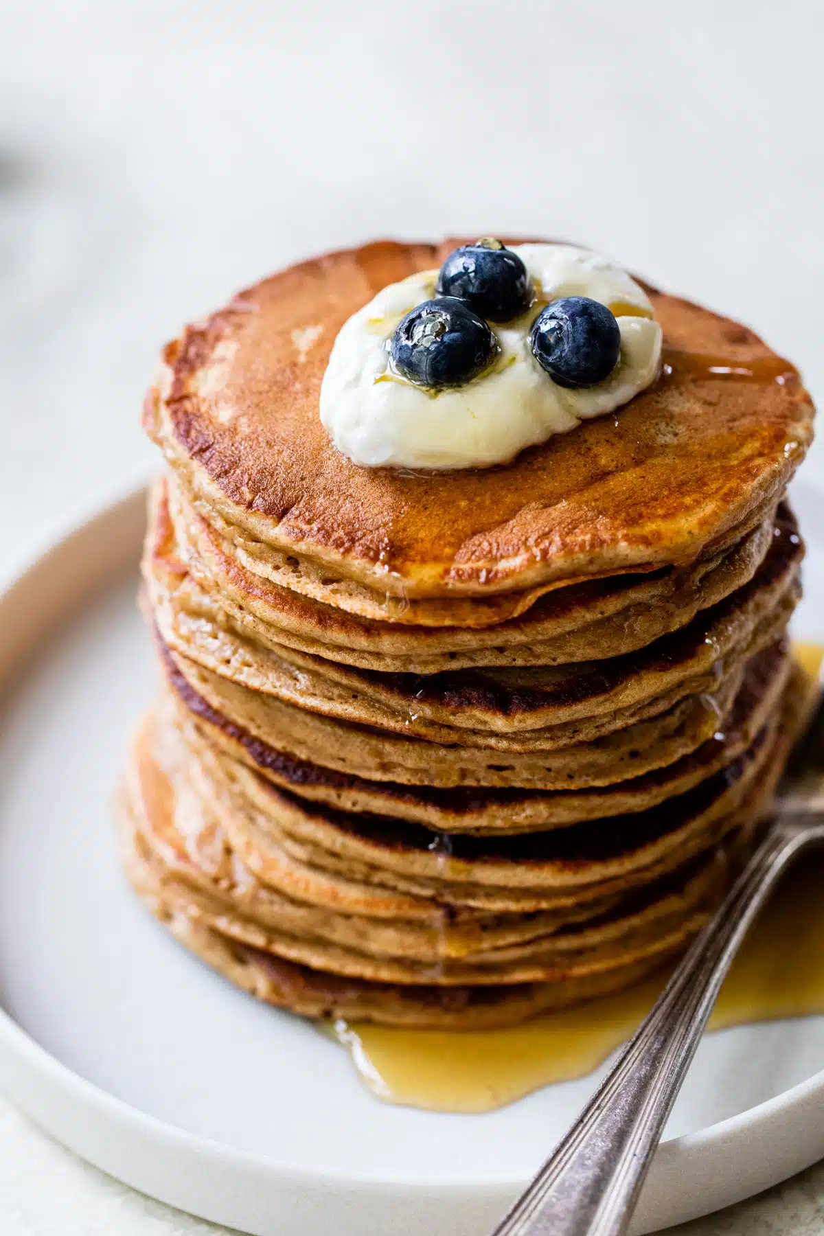 a stack of pancakes with yogurt and blueberries on top