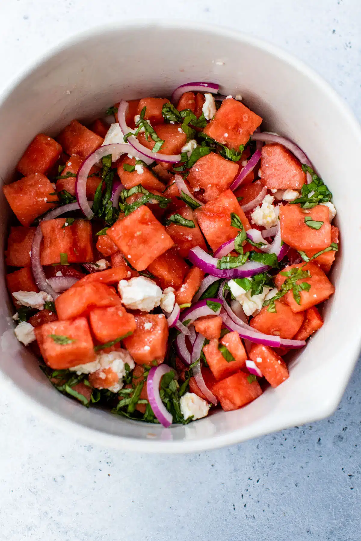 watermelon basil salad mixed together in a large bowl