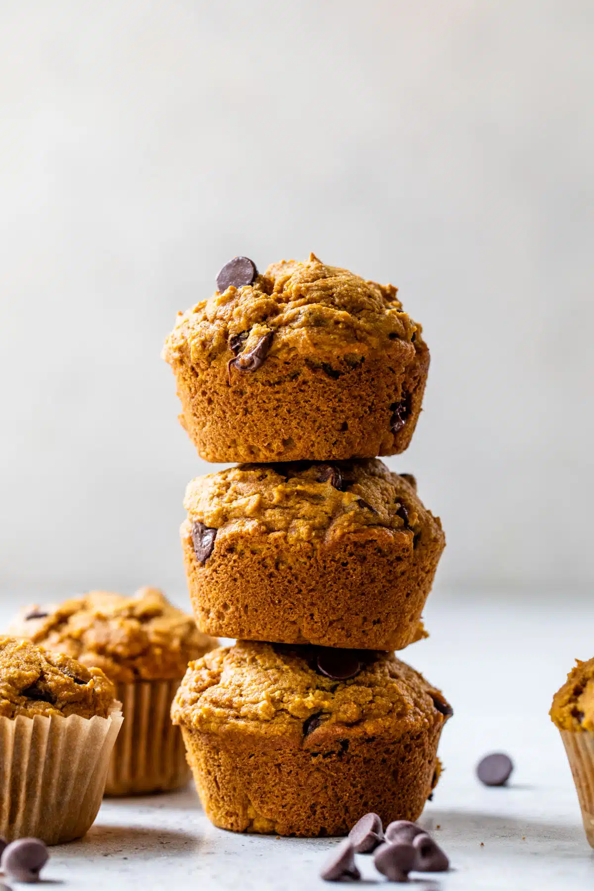 a side-view of three pumpkin chocolate chip muffins stacked on top of each other