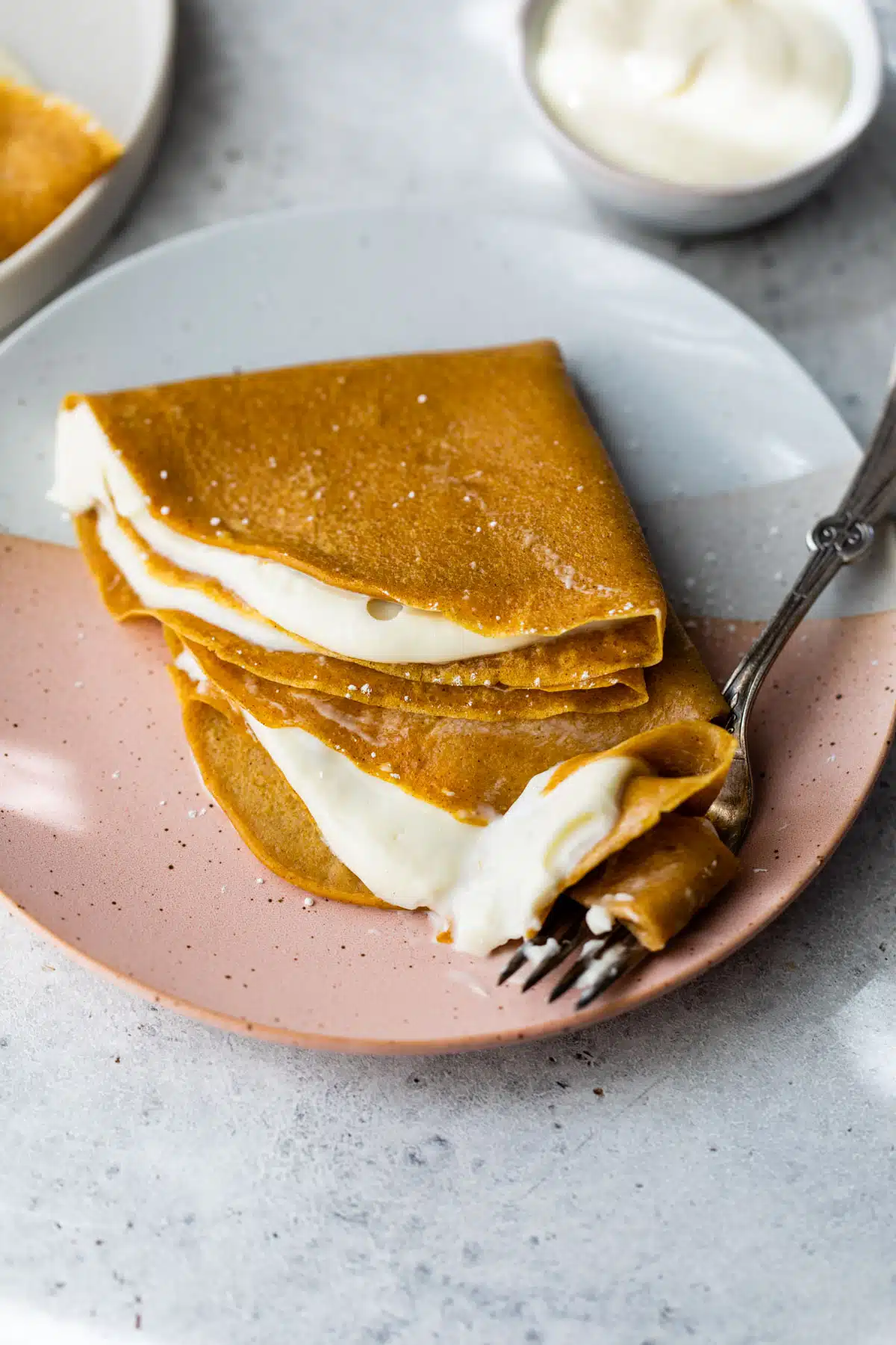 two crepes stacked on top of each other on a plate with a fork