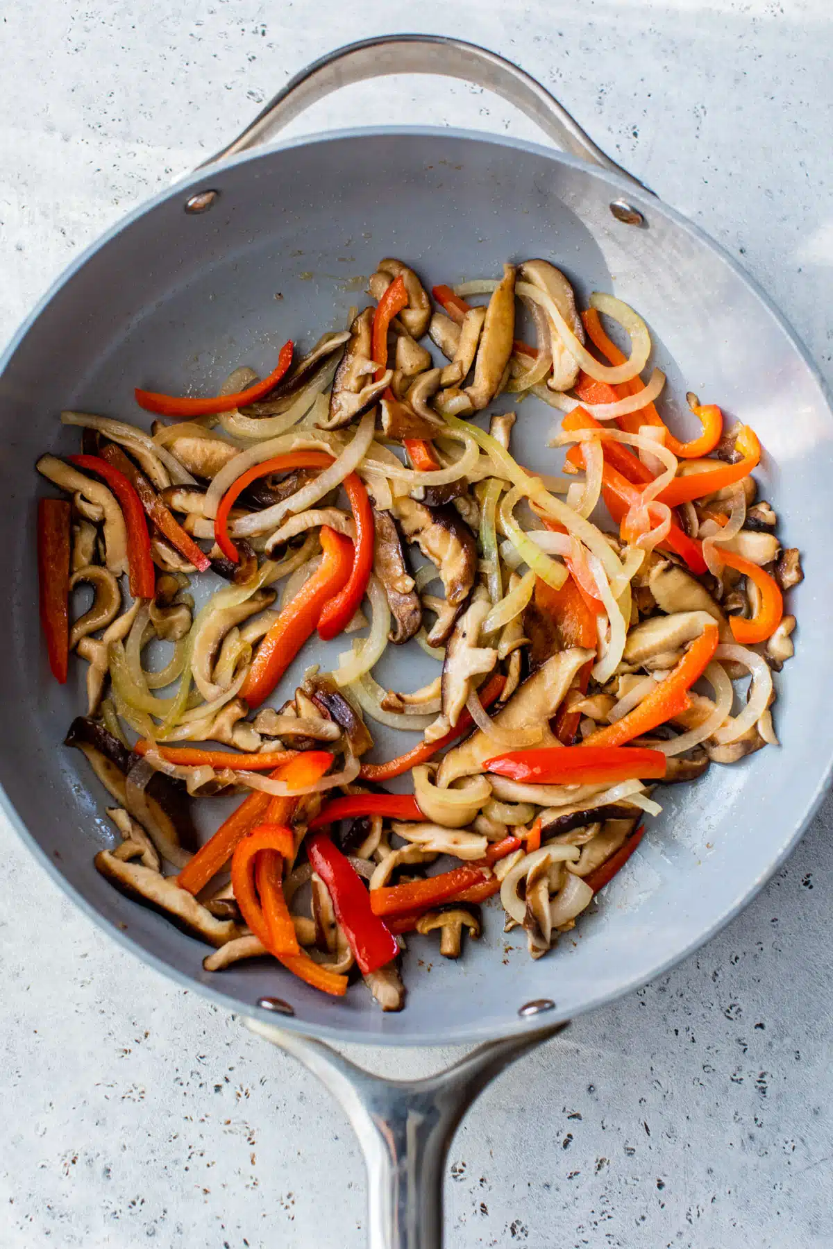 onion, peppers, and mushrooms cooking in a large skillet