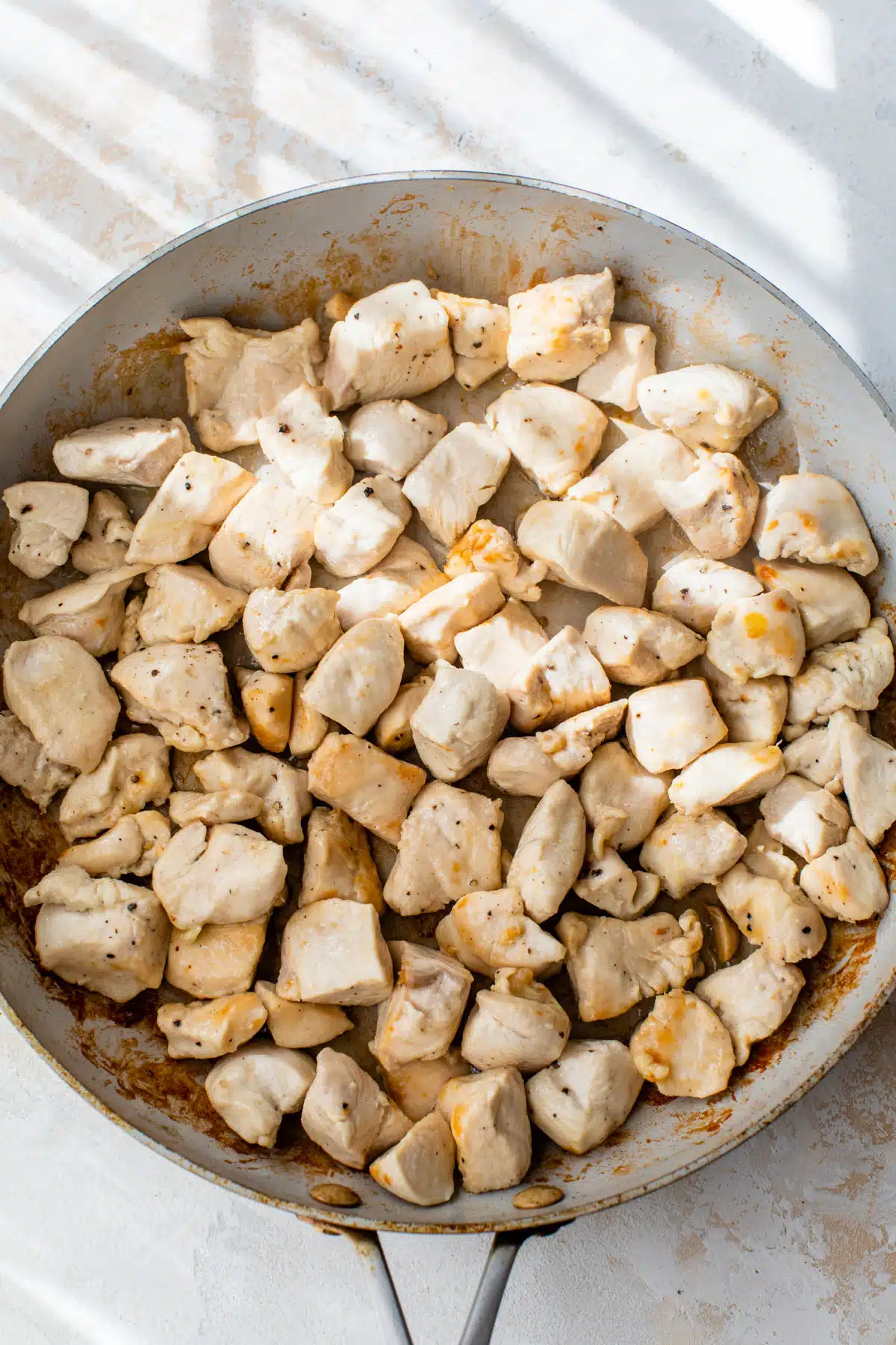 chicken pieces cooking in a skillet