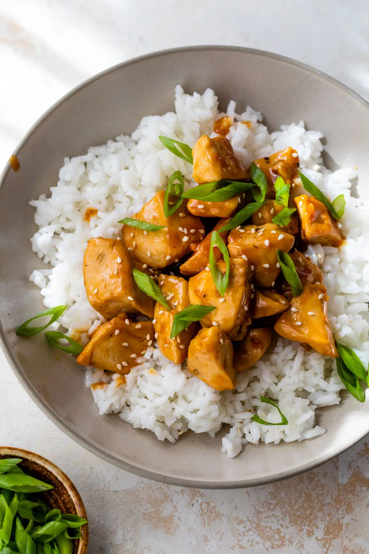 orange chicken on top of rice in a bowl