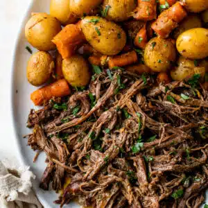 shredded beef, cooked carrots and cooked baby potatoes on a serving platter