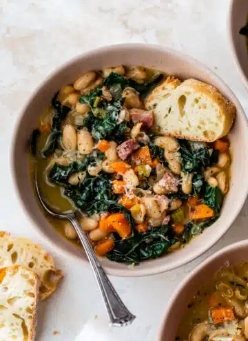 white bean soup in a bowl with a spoon and a slice of bread