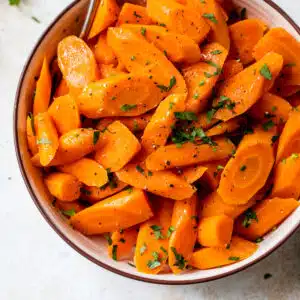 instant pot carrots inside a bowl with a fork and fresh parsley on top