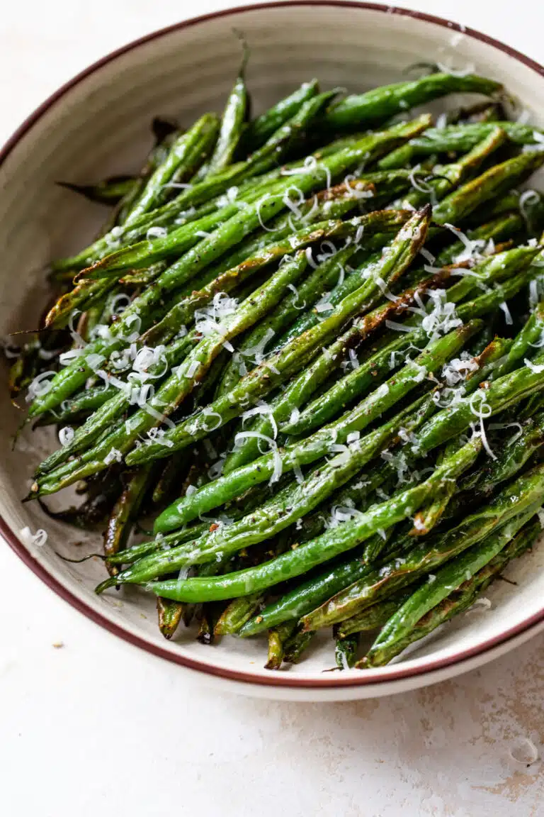 air fryer green beans in a bowl with grated cheese on top