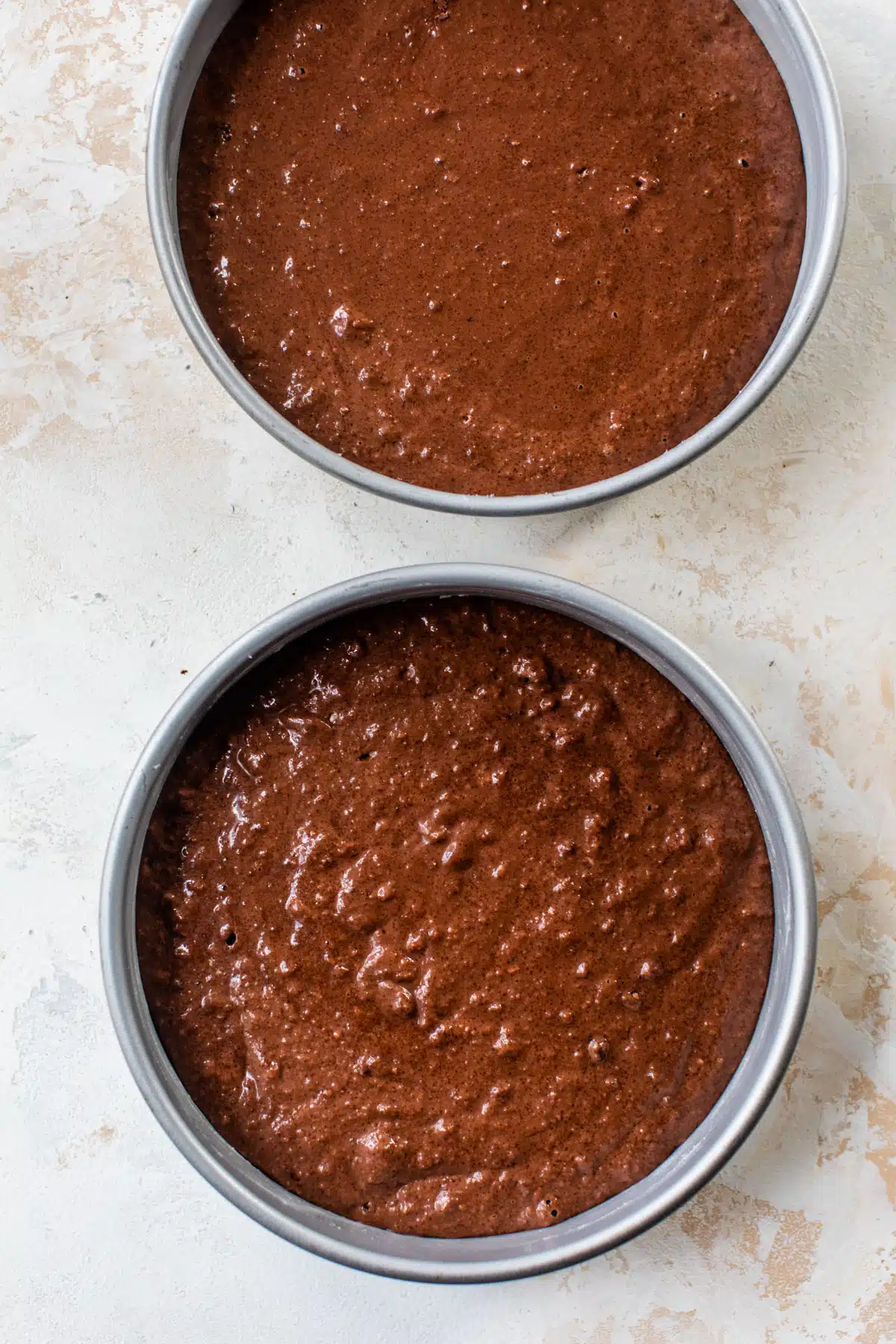 chocolate cake batter in two round cake pans