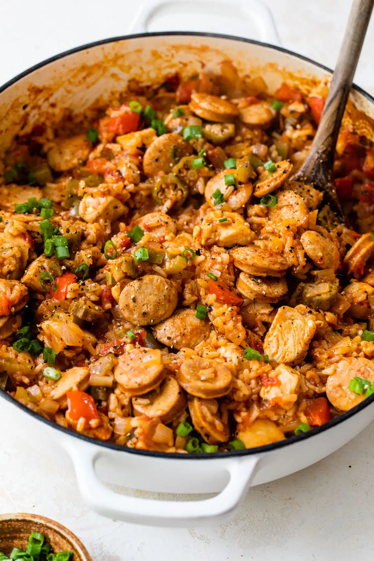chicken and sausage jambalaya in a dutch oven with a wooden spoon
