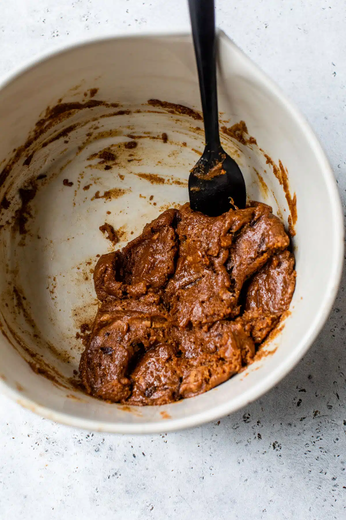 flourless chocolate chip cookie batter mixed together in a large bowl with a spatula