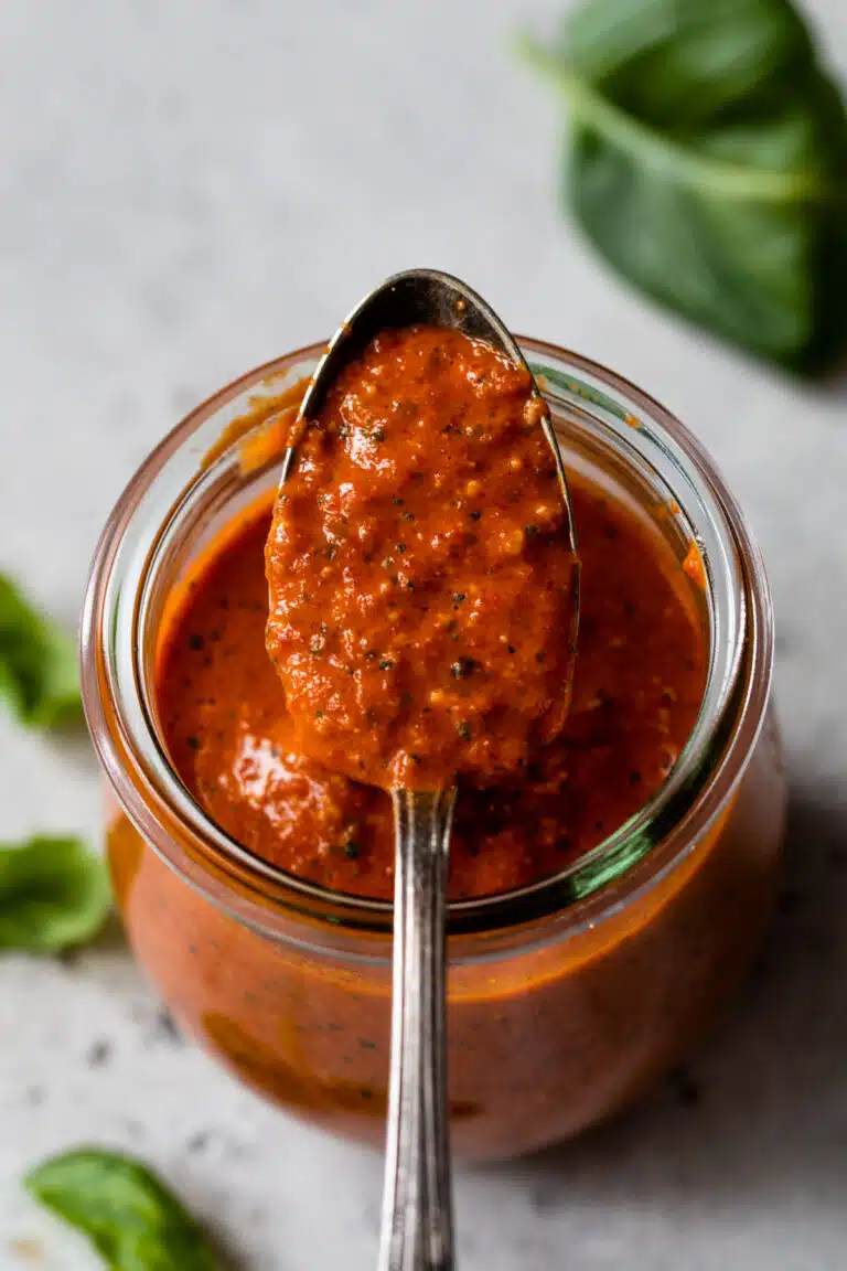 a spoonful of red pepper pesto out of a jar
