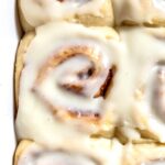 close up on a cream cheese frosting-topped vegan cinnamon roll.