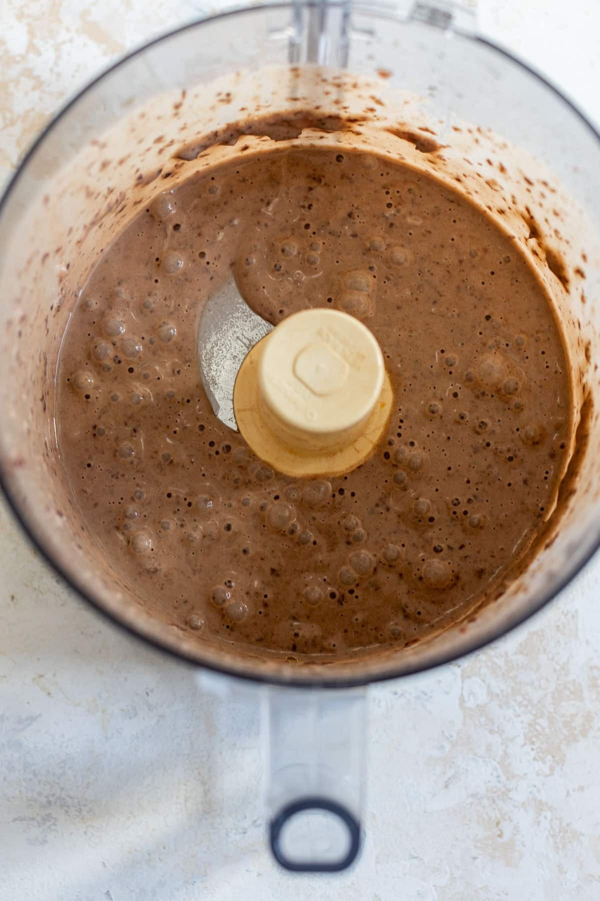 overhead view of black bean brownie batter in a food processor.