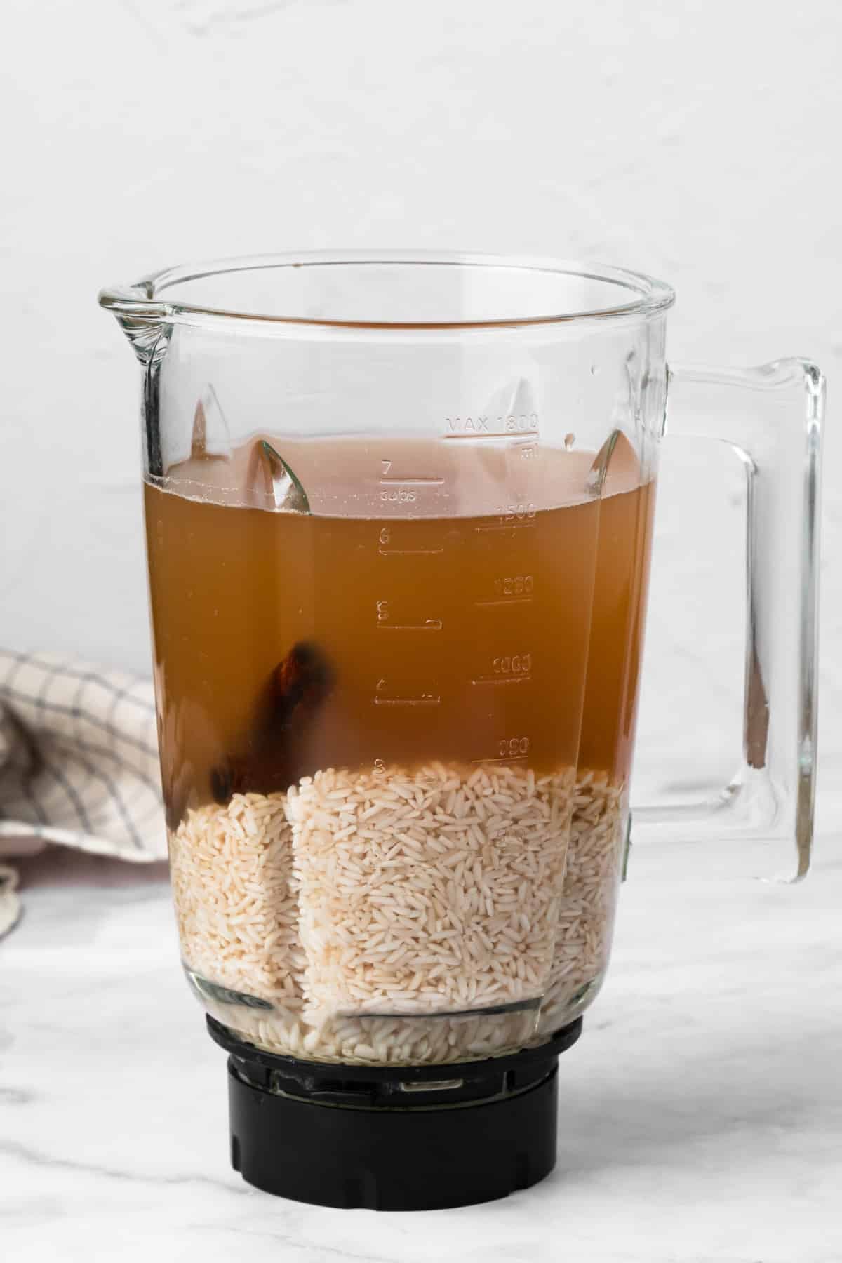 side view of the soaked ingredients for horchata in a large blender.