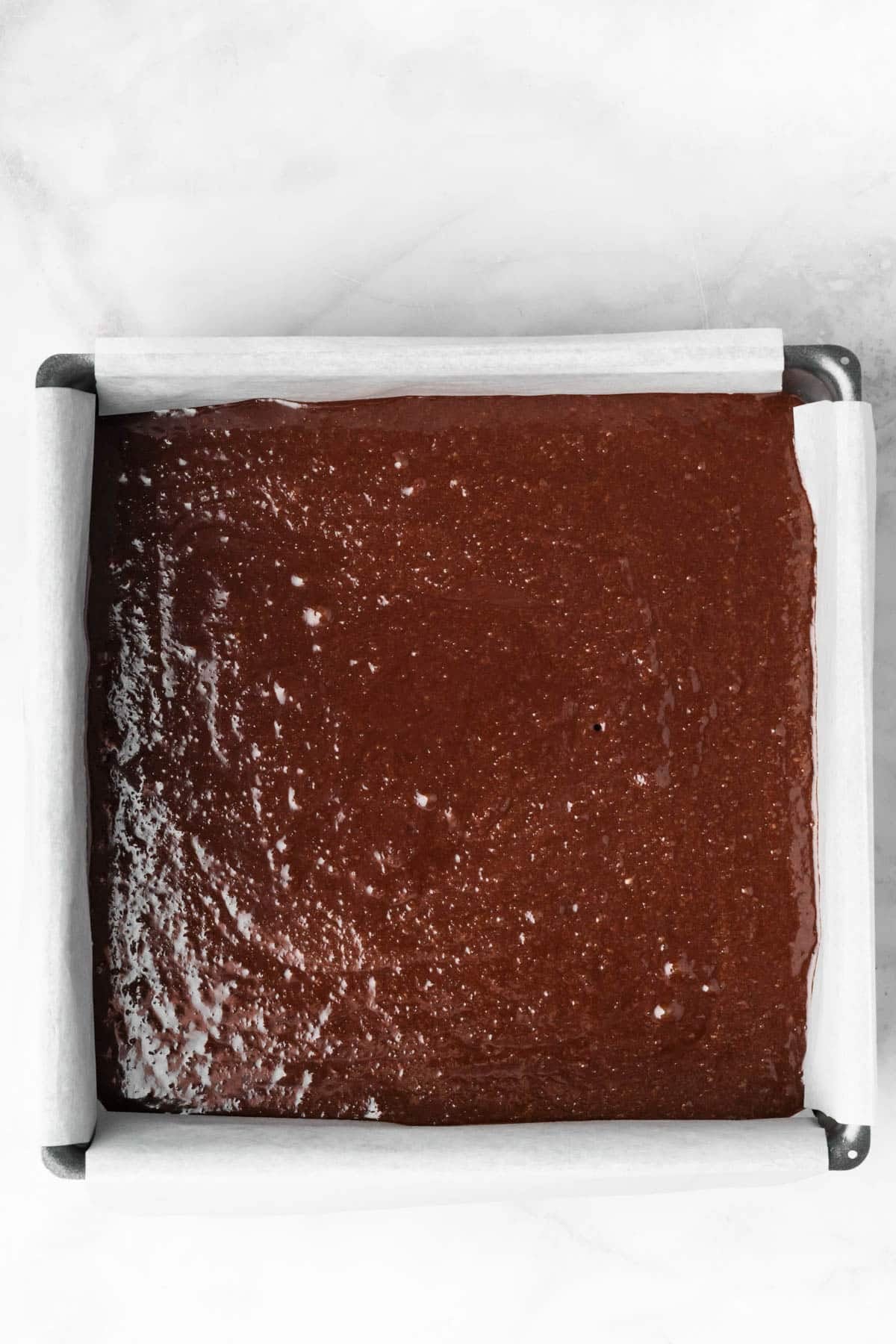 overhead view of paleo brownie batter in a baking pan.